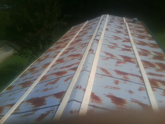 Rusted metal roof panels with new wood purlins before replacement — Storm Damage Roof Repair in Midway City by Roofing Brothers