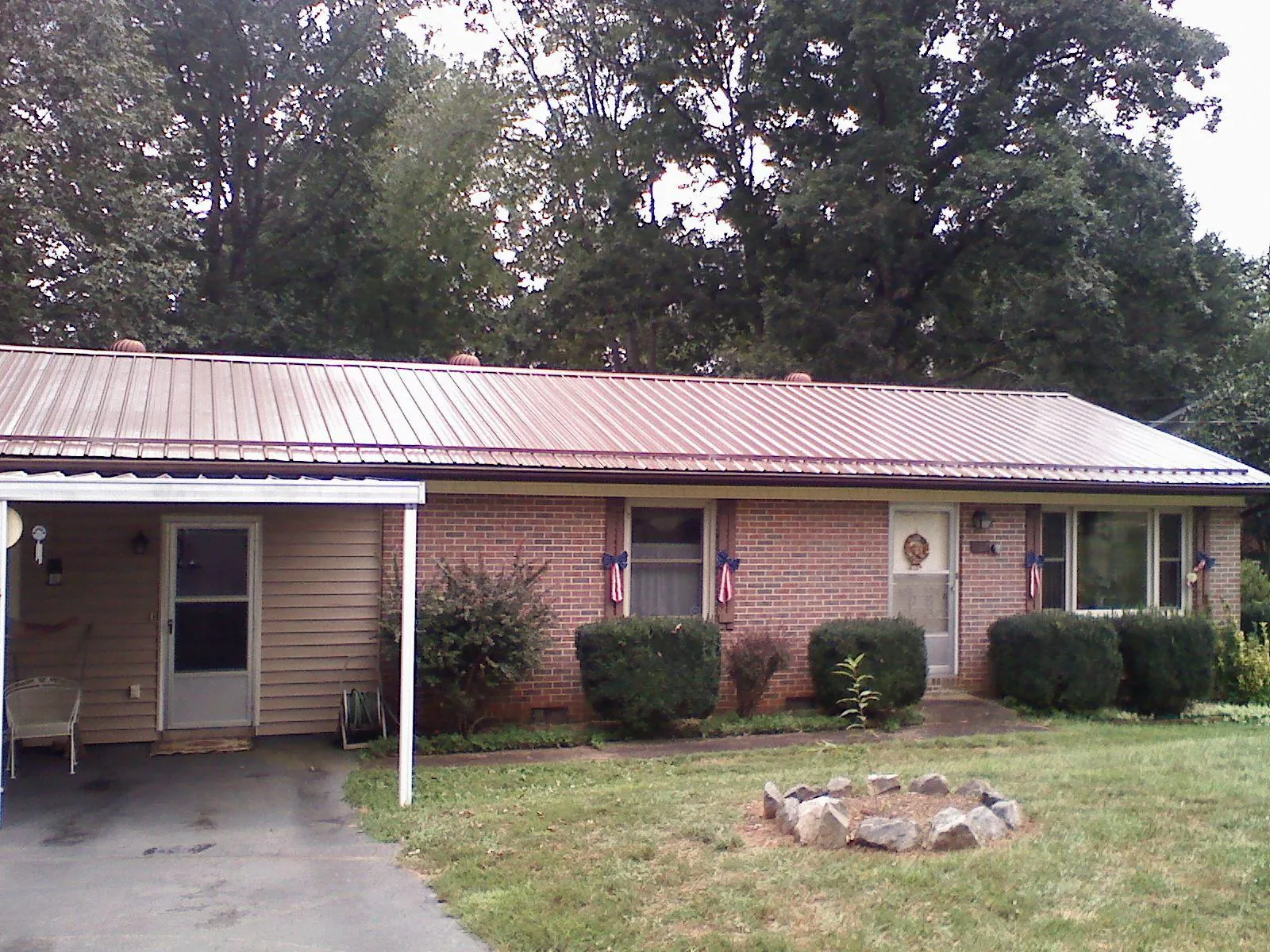 Bronze metal roof and carport on a brick ranch home — Roof Repair work by our crew in Midway City
